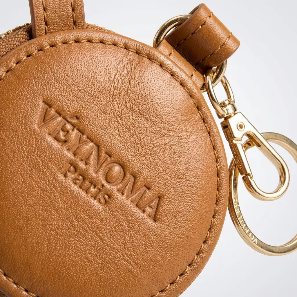 Detailaufnahme: Hochwertiges veganes Kunstleder in Braun mit geprägtem VÉYNOMA Paris Logo und sauberer Naht.