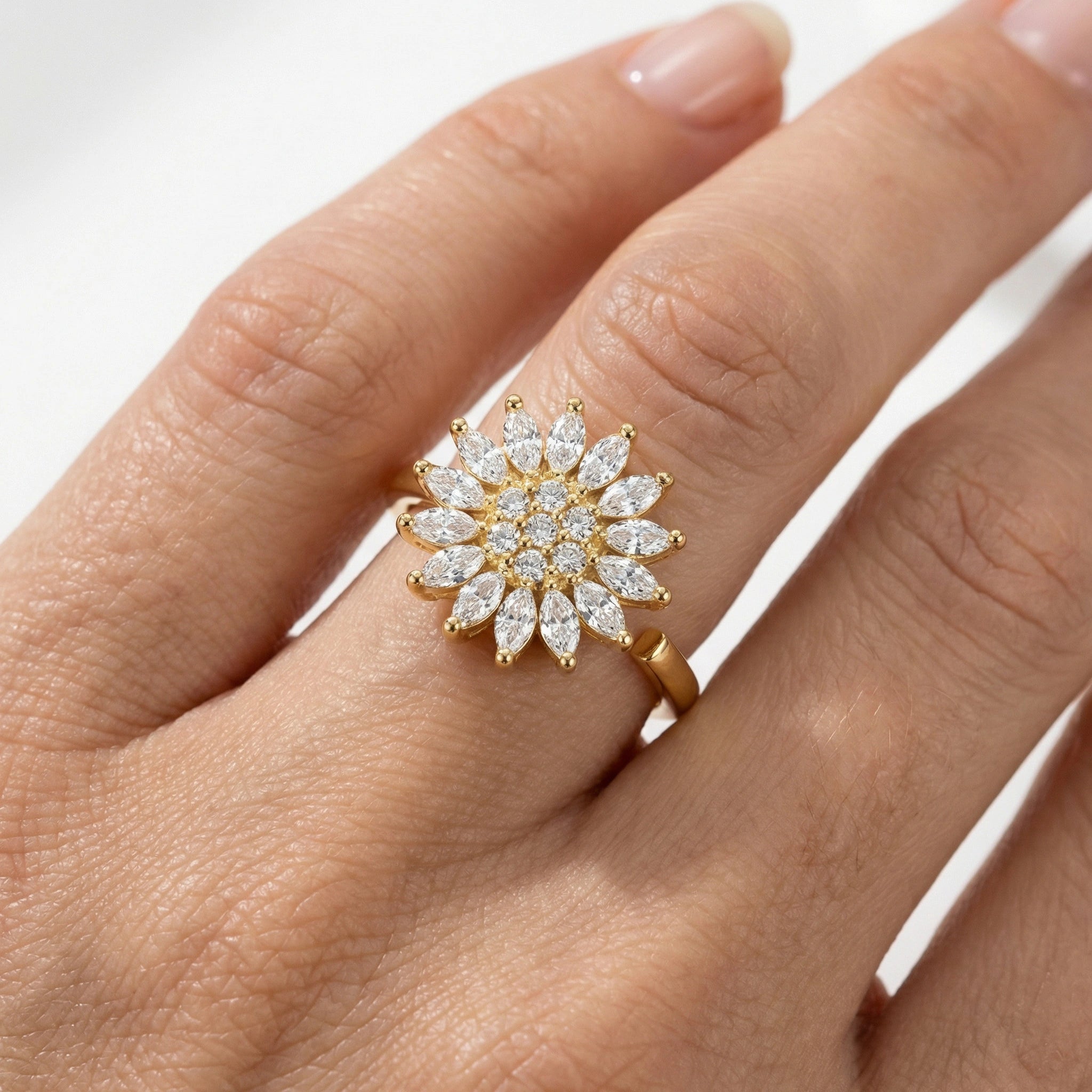 Nahaufnahme des Lux Anti-Stress Rings am Finger, besetzt mit vielen klaren Kristallen, elegantes Design aus 18k Gold.