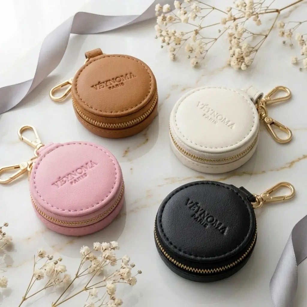 Ästhetische Schmuckaufbewahrung für die Reise: Runde Mini-Etuis aus veganem Leder auf Marmor mit Gold-Details.