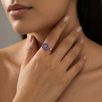 Model trägt eleganten silbernen Ring mit lila Blüte am Zeigefinger, modisches Accessoire gegen Stress und Unruhe.