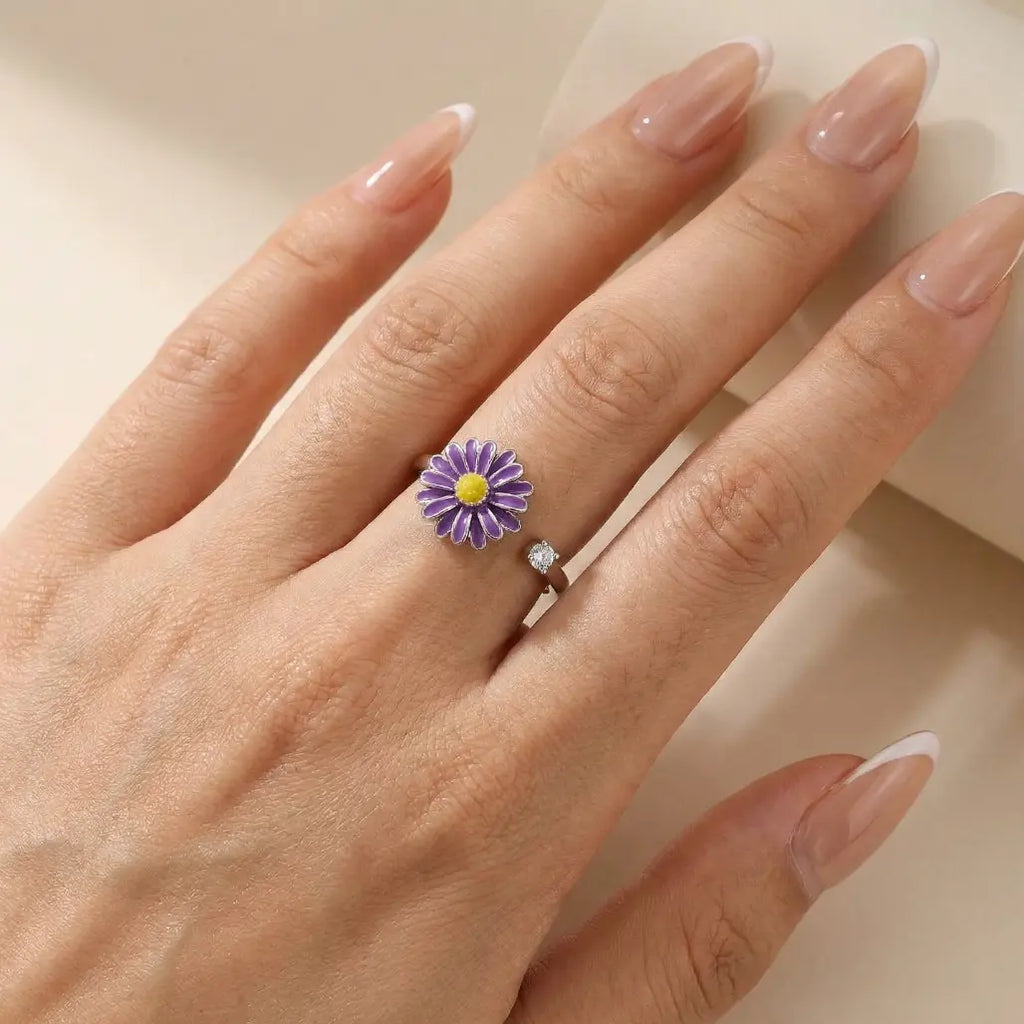 VÉYNOMA Eden Ring am Finger: Offener Silberring mit drehbarem lila Gänseblümchen-Motiv (Emaille) und funkelndem Zirkonia-Kristall. Größenverstellbarer Anti-Stress Schmuck mit floralem Design.